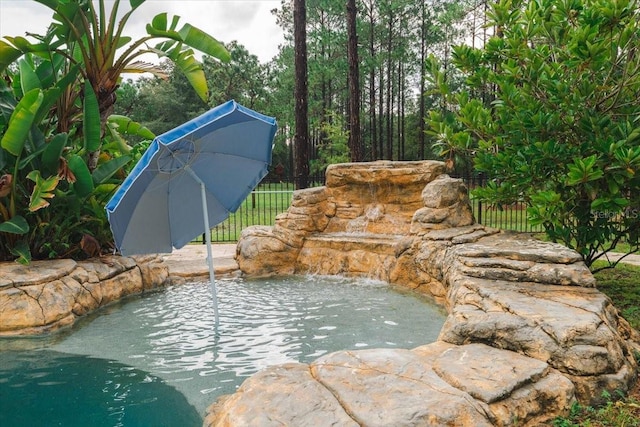 view of pool featuring fence