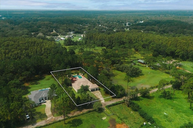 drone / aerial view featuring a wooded view