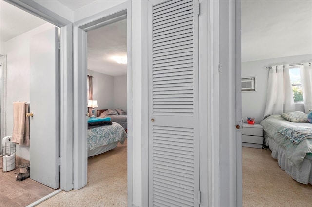 bedroom with a closet, an AC wall unit, and speckled floor