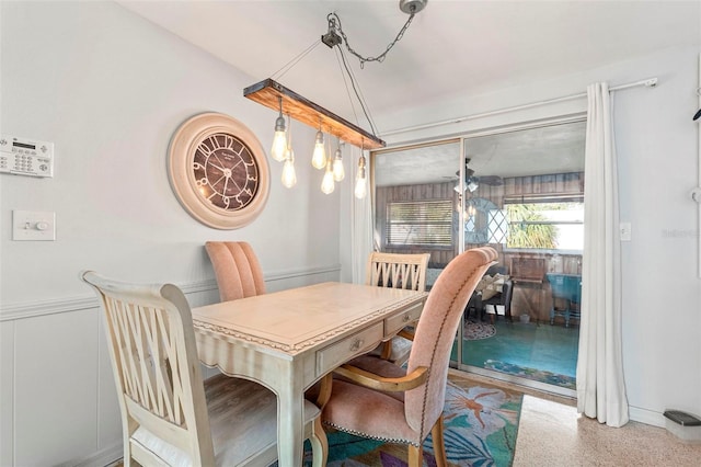 dining space featuring a wainscoted wall and speckled floor