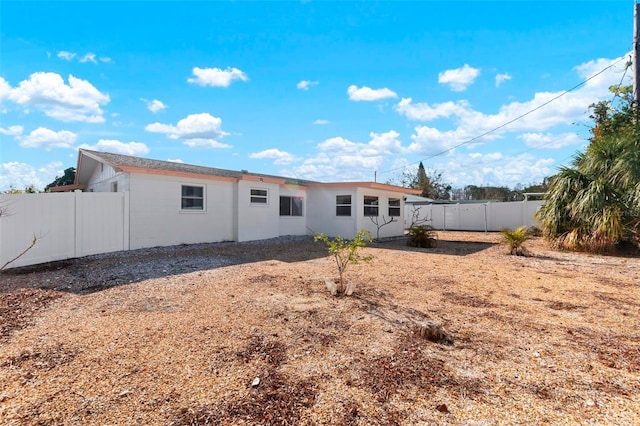 rear view of house with a fenced backyard