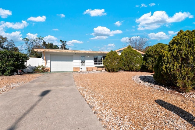 single story home with an attached garage, fence, and concrete driveway