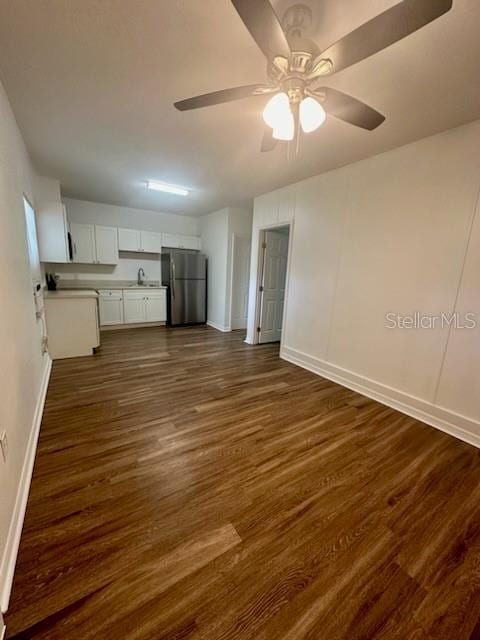 kitchen featuring ceiling fan, white cabinets, light countertops, freestanding refrigerator, and dark wood finished floors