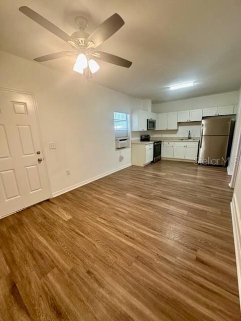 kitchen featuring stainless steel appliances, dark wood-style flooring, a ceiling fan, white cabinets, and light countertops