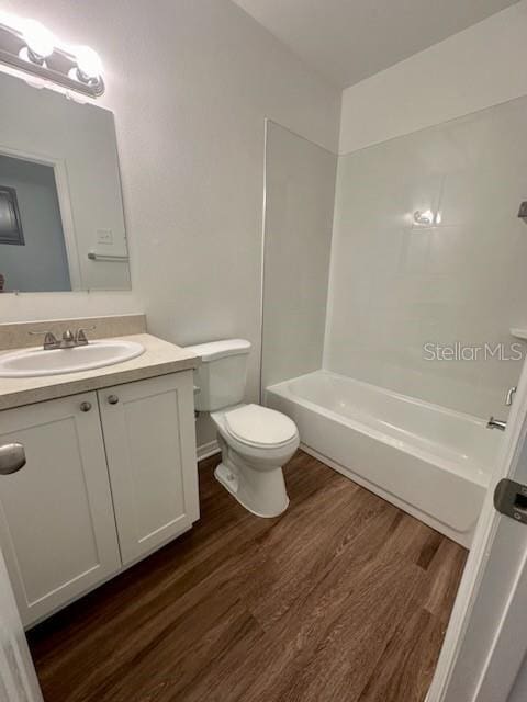 full bathroom featuring bathing tub / shower combination, vanity, toilet, and wood finished floors