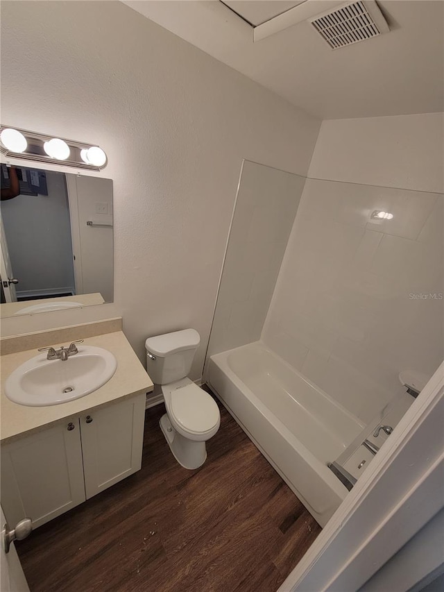 full bathroom with visible vents, toilet, vanity, wood finished floors, and  shower combination