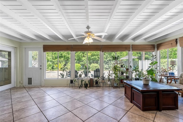 unfurnished sunroom featuring a ceiling fan and beamed ceiling