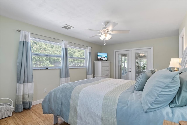 bedroom featuring wood finished floors, visible vents, baseboards, access to exterior, and french doors