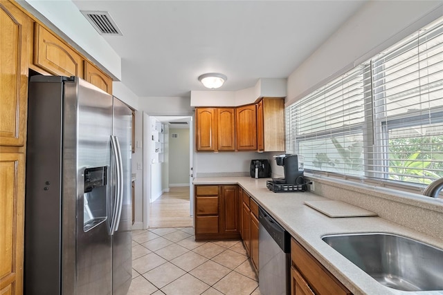 kitchen with light countertops, visible vents, appliances with stainless steel finishes, built in study area, and a sink