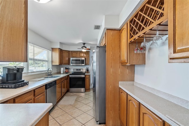 kitchen with visible vents, appliances with stainless steel finishes, brown cabinets, a sink, and light tile patterned flooring