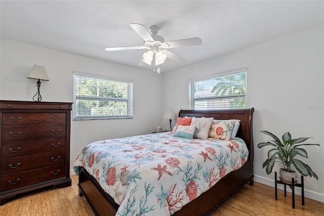 bedroom with a ceiling fan, light wood-type flooring, and baseboards