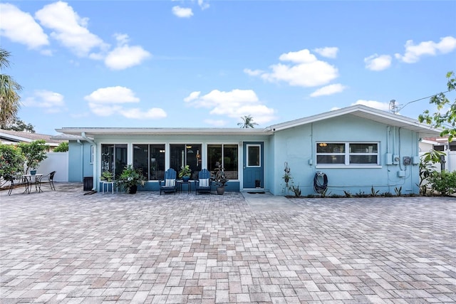 back of house featuring a patio area, fence, and a sunroom