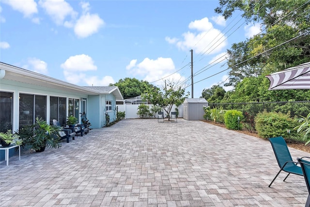 view of patio with a storage unit, an outdoor structure, and a fenced backyard