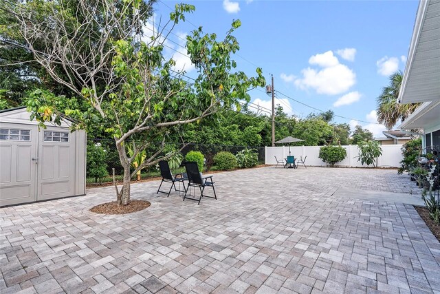 view of patio / terrace with a shed, an outdoor structure, and a fenced backyard