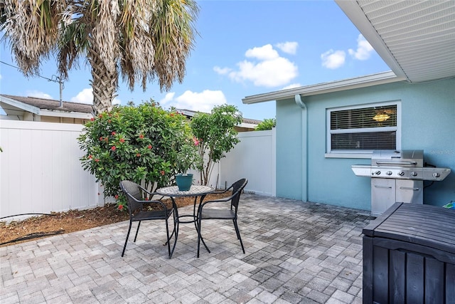 view of patio / terrace with outdoor dining area, a fenced backyard, and a grill