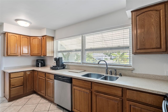 kitchen with brown cabinets, dishwasher, a sink, and light tile patterned floors