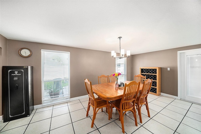 dining area featuring a notable chandelier, baseboards, and light tile patterned floors