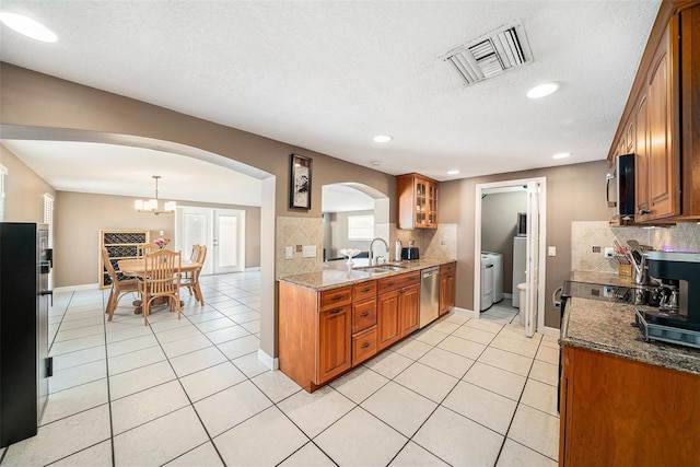 kitchen with brown cabinets, light tile patterned floors, visible vents, appliances with stainless steel finishes, and a sink