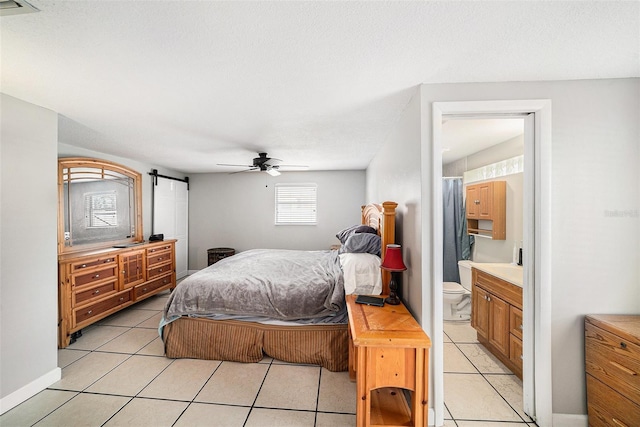 bedroom featuring light tile patterned flooring, ensuite bath, visible vents, and a ceiling fan