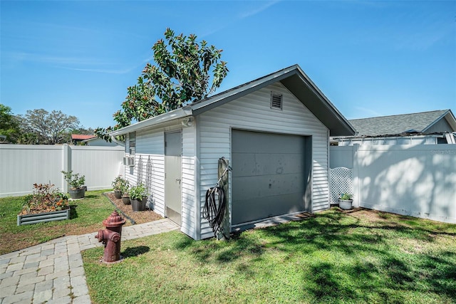 detached garage featuring driveway and fence