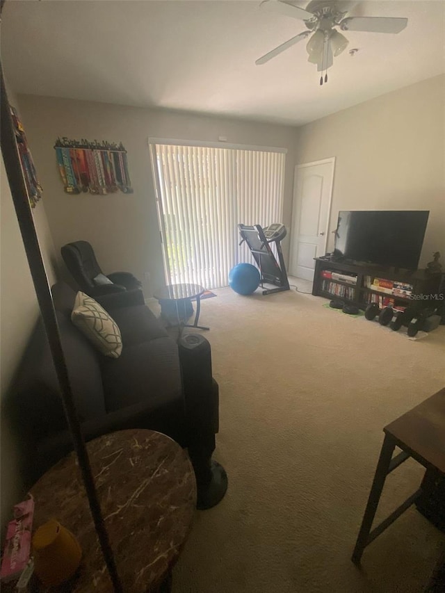 sitting room with ceiling fan and carpet