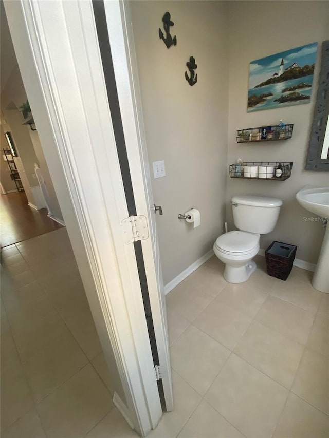 bathroom with tile patterned flooring, toilet, and baseboards