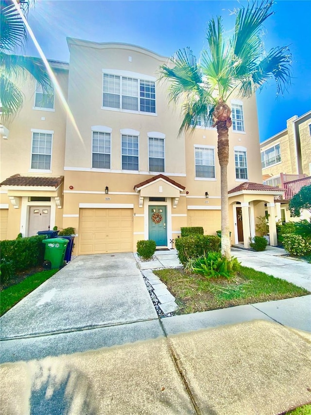 view of property with driveway, an attached garage, and stucco siding