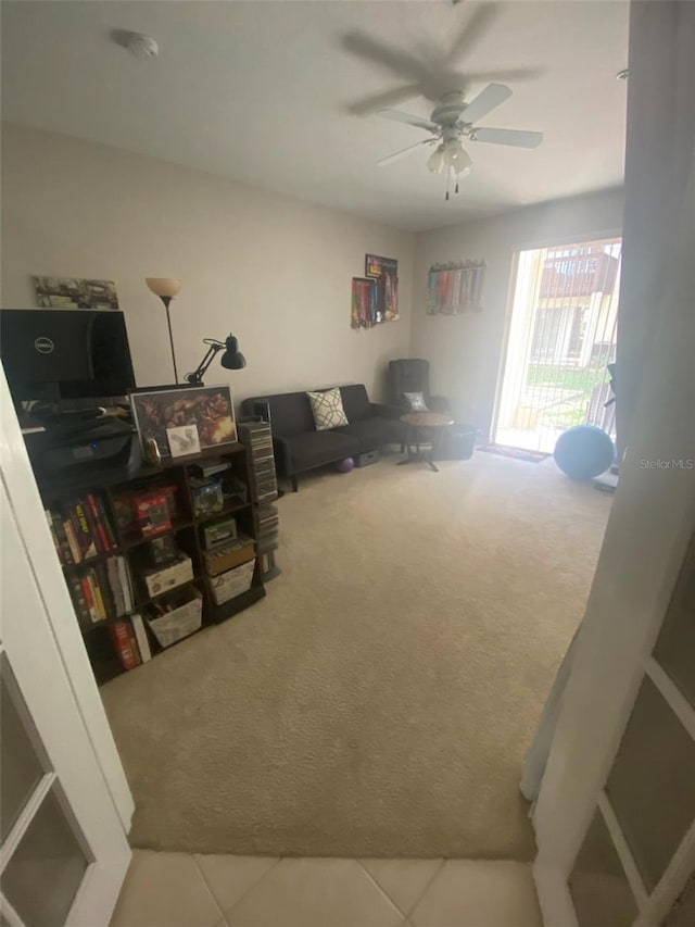 interior space featuring ceiling fan, carpet, and tile patterned floors