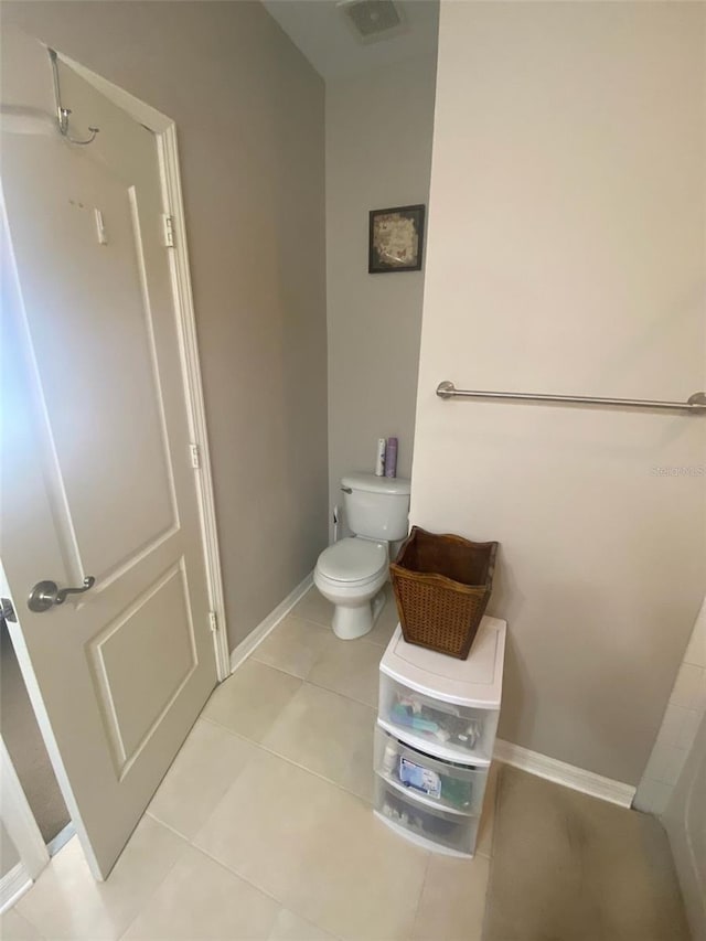 bathroom with baseboards, visible vents, toilet, and tile patterned floors