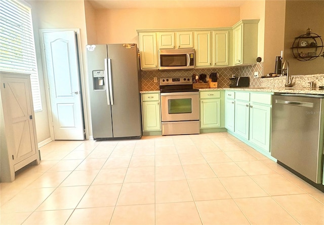 3128 Bayshore Oaks Dr, Tampa, FL 33611 - kitchen with appliances with stainless steel finishes, tasteful backsplash, light stone countertops, and light tile patterned floors