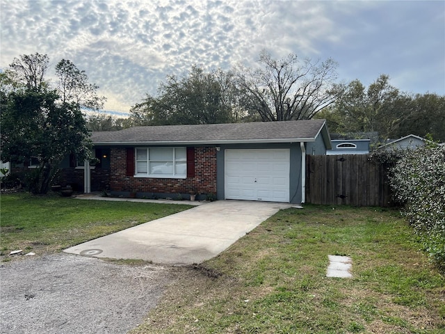 ranch-style house featuring a garage, brick siding, concrete driveway, fence, and a front yard