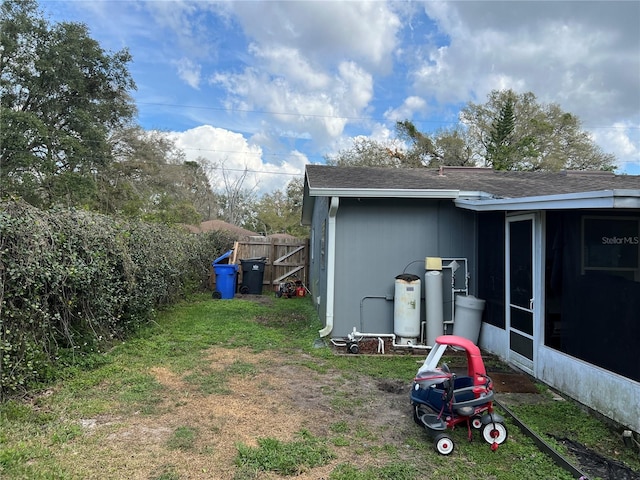 view of yard with a sunroom and fence