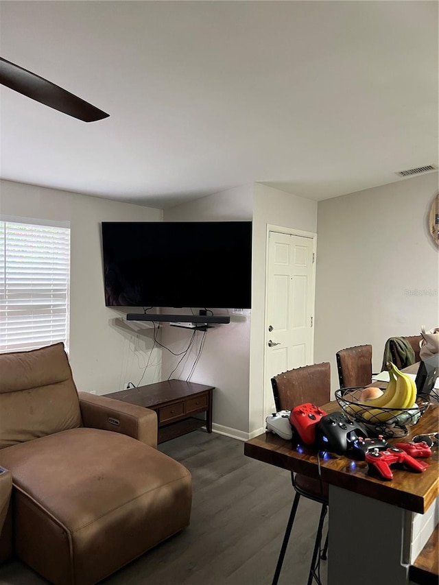 living room featuring visible vents, baseboards, and wood finished floors