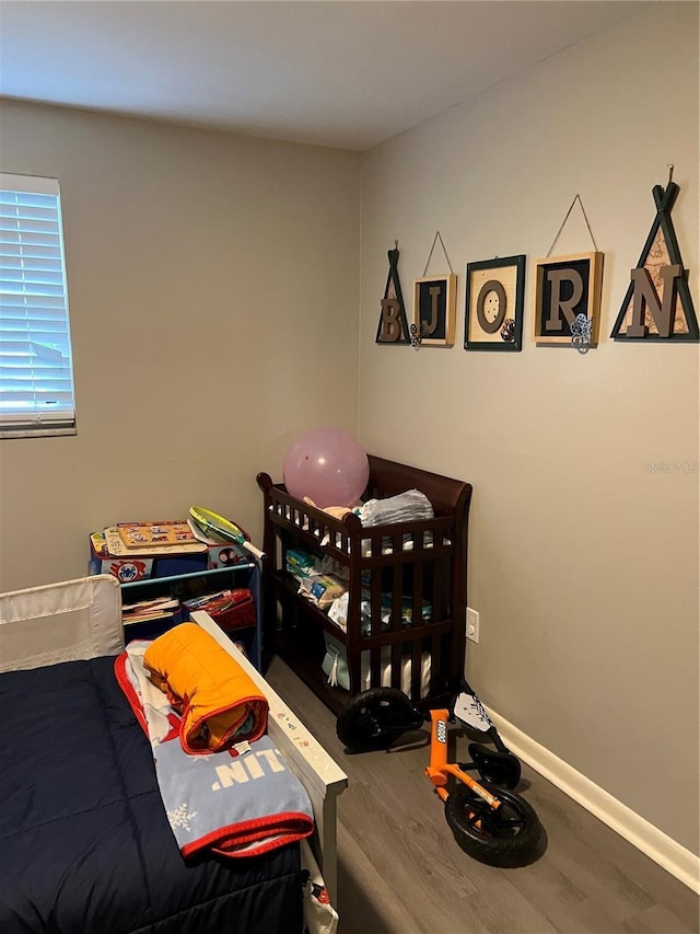 bedroom featuring wood finished floors and baseboards