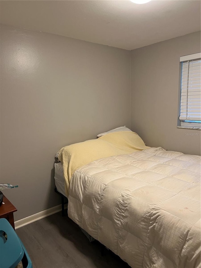 bedroom with wood finished floors and baseboards