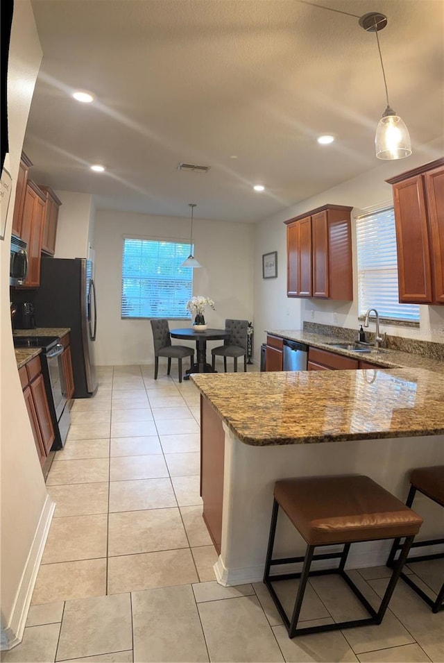 kitchen featuring visible vents, a peninsula, a sink, stainless steel dishwasher, and range with electric stovetop