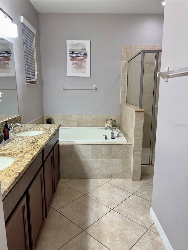 full bath featuring double vanity, a stall shower, tile patterned floors, a garden tub, and a sink