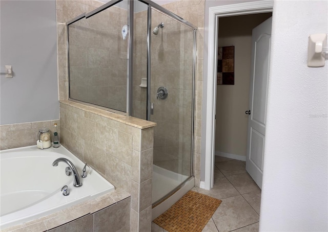 full bath featuring a stall shower, a garden tub, and tile patterned floors