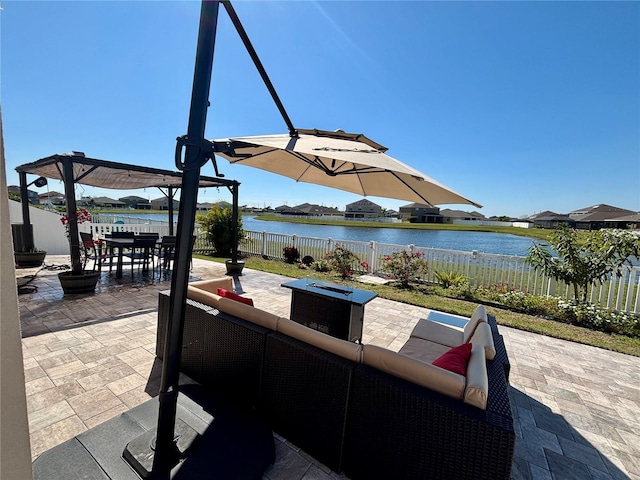 view of patio / terrace featuring outdoor dining area, an outdoor living space with a fire pit, a water view, and a fenced backyard