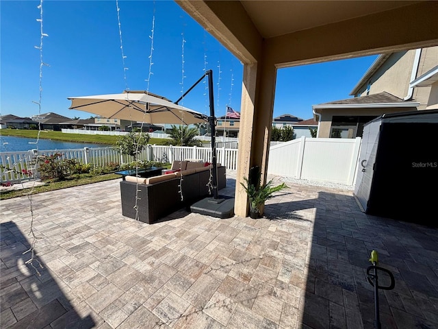 view of patio with an outdoor hangout area, a water view, and a fenced backyard