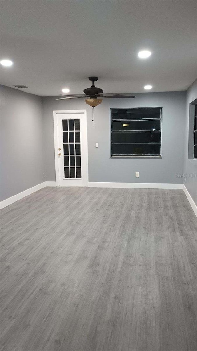 unfurnished room with a ceiling fan, baseboards, wood finished floors, and recessed lighting