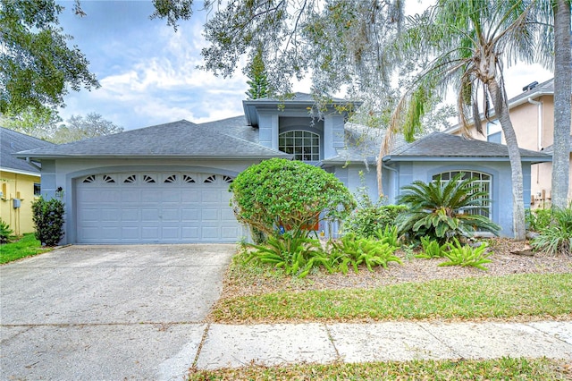 view of front of home with a garage, concrete driveway, a shingled roof, and stucco siding