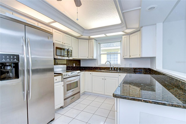 kitchen with light tile patterned floors, appliances with stainless steel finishes, ornamental molding, white cabinetry, and a sink