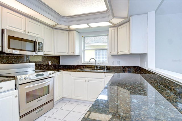 kitchen with appliances with stainless steel finishes, a sink, and white cabinets