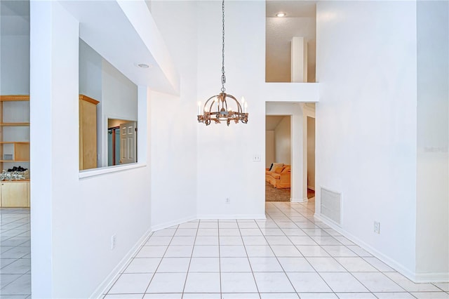 unfurnished room featuring baseboards, visible vents, an inviting chandelier, and light tile patterned floors