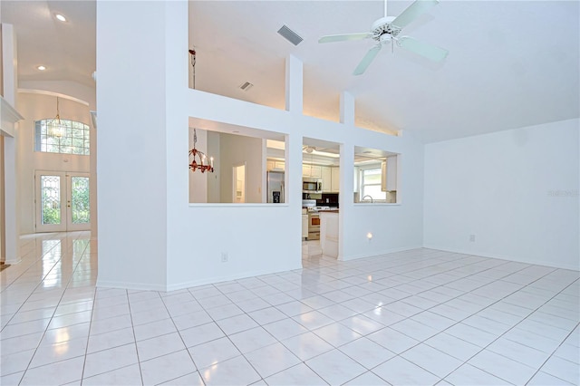 empty room with high vaulted ceiling, french doors, light tile patterned flooring, and visible vents