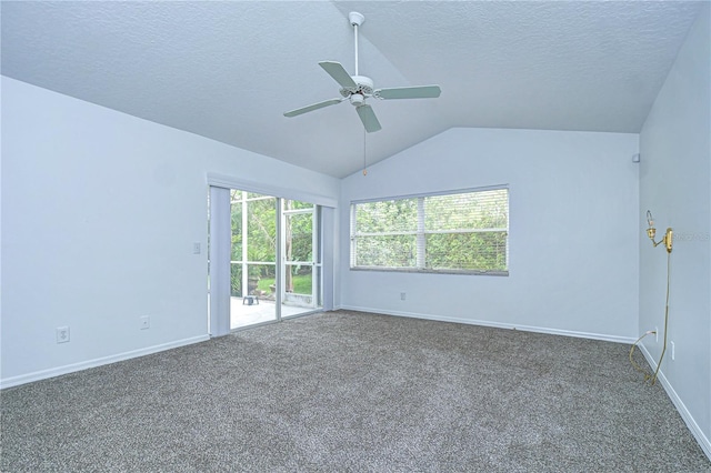 carpeted empty room with ceiling fan, baseboards, vaulted ceiling, and a textured ceiling