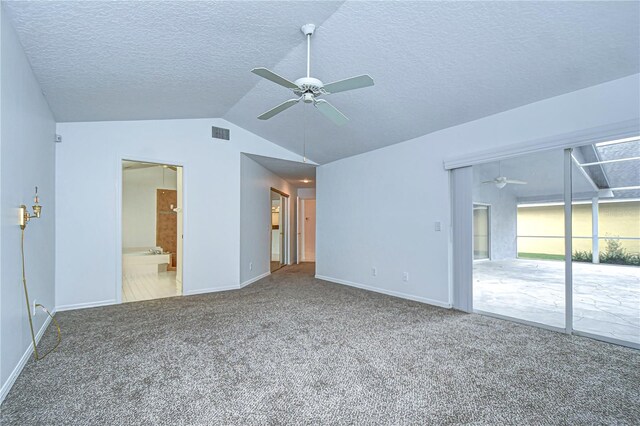 interior space with carpet floors, visible vents, vaulted ceiling, and a ceiling fan