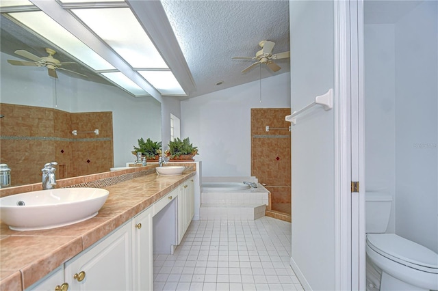 full bath featuring a garden tub, a sink, a textured ceiling, and tile patterned floors