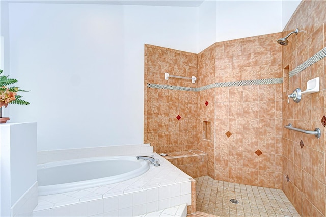 full bathroom with tiled shower and a bath